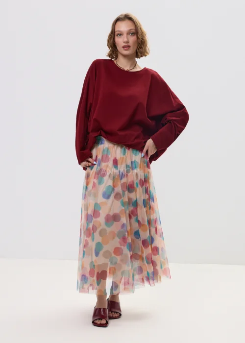 Zwiewna spódnica midi z tiulu w pastelowe, wielokolorowe kropki, o lekkim, transparentnym materiale i rozkloszowanym fasonie. Elastyczna talia zapewnia komfort noszenia, a print dodaje stylizacji świeżości i lekkości