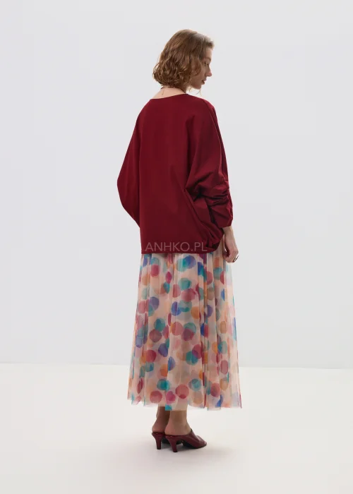Zwiewna spódnica midi z tiulu w pastelowe, wielokolorowe kropki, o lekkim, transparentnym materiale i rozkloszowanym fasonie. Elastyczna talia zapewnia komfort noszenia, a print dodaje stylizacji świeżości i lekkości