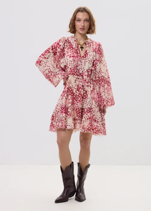 Sukienka mini boho w odcieniach różu i kremu, zwiewny fason z falbaną i wiązaniem w talii – stylizacja z kowbojkami.