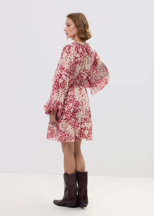 Sukienka mini boho w odcieniach różu i kremu, zwiewny fason z falbaną i wiązaniem w talii – stylizacja z kowbojkami.