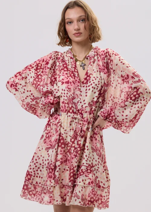 Sukienka mini boho w odcieniach różu i kremu, zwiewny fason z falbaną i wiązaniem w talii – stylizacja z kowbojkami.