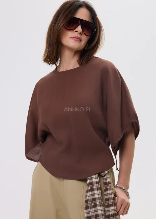 Brązowa bluzka damska o luźnym kroju z szerokimi rękawami i wiązaniami, lekki materiał, casualowa stylizacja.