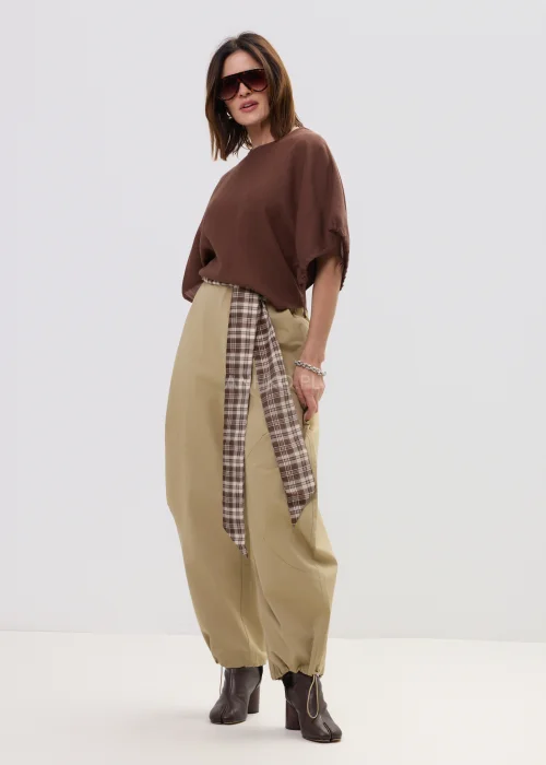 Brązowa bluzka damska o luźnym kroju z szerokimi rękawami i wiązaniami, lekki materiał, casualowa stylizacja.