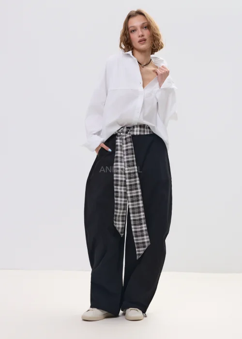 Biała koszula damska oversize z długim rękawem i klasycznym kołnierzykiem, luźny fason, minimalistyczna stylizacja.