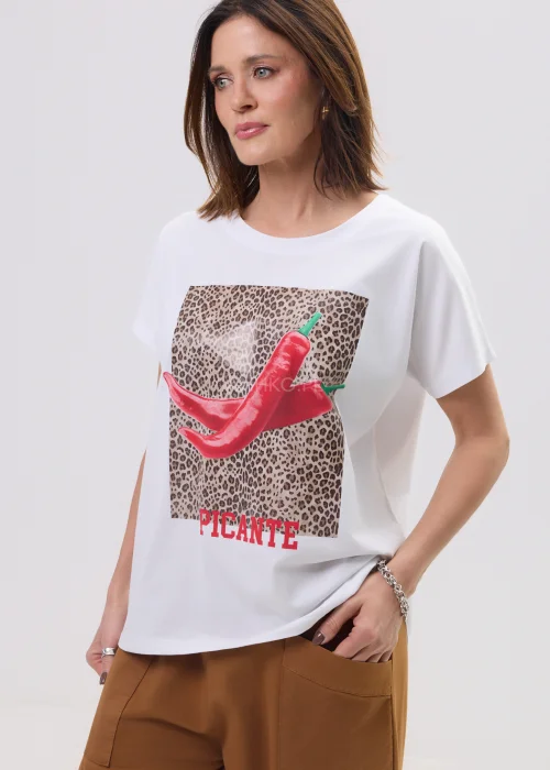 Biały t-shirt z nadrukiem czerwonych papryczek na tle panterki i napisem „PICANTE”, luźny fason – stylizacja z brązowymi spodniami.