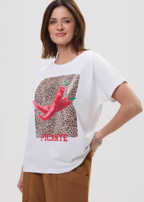 Biały t-shirt z nadrukiem czerwonych papryczek na tle panterki i napisem „PICANTE”, luźny fason – stylizacja z brązowymi spodniami.