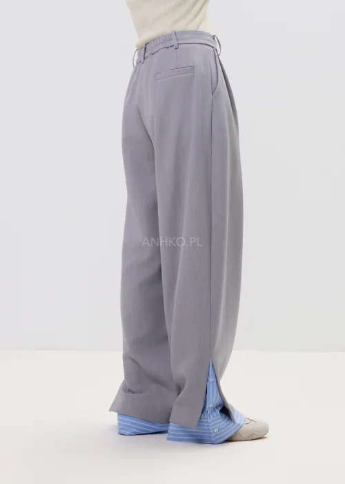 Szerokie spodnie damskie typu wide leg w kolorze szarym z wysokim stanem, elegancki fason – stylizacja ze sneakersami i koszulą.