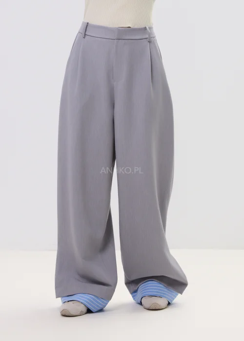 Szerokie spodnie damskie typu wide leg w kolorze szarym z wysokim stanem, elegancki fason – stylizacja ze sneakersami i koszulą.