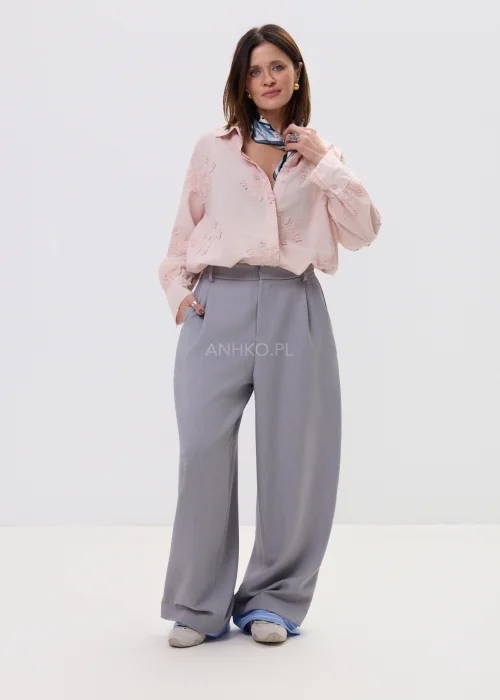 Koszula oversize pudrowy róż z delikatnym haftem kwiatowym, lekka i zwiewna, zapinana na guziki – elegancka stylizacja z apaszką i spodniami w kant.