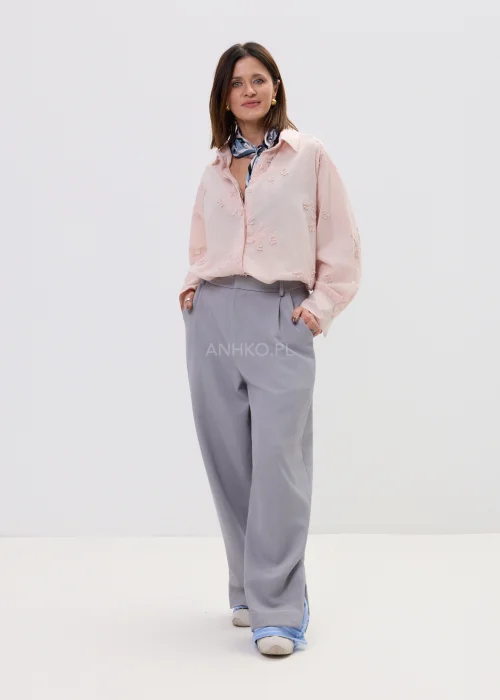 Koszula oversize pudrowy róż z delikatnym haftem kwiatowym, lekka i zwiewna, zapinana na guziki – elegancka stylizacja z apaszką i spodniami w kant.