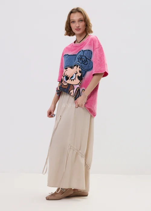 Beżowa spódnica maxi z elastyczną talią i dekoracyjnymi marszczeniami, lekki materiał, asymetryczne przeszycia – stylizacja z balerinami.