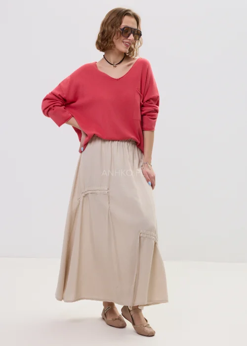 Beżowa spódnica maxi z elastyczną talią i dekoracyjnymi marszczeniami, lekki materiał, asymetryczne przeszycia – stylizacja z balerinami.