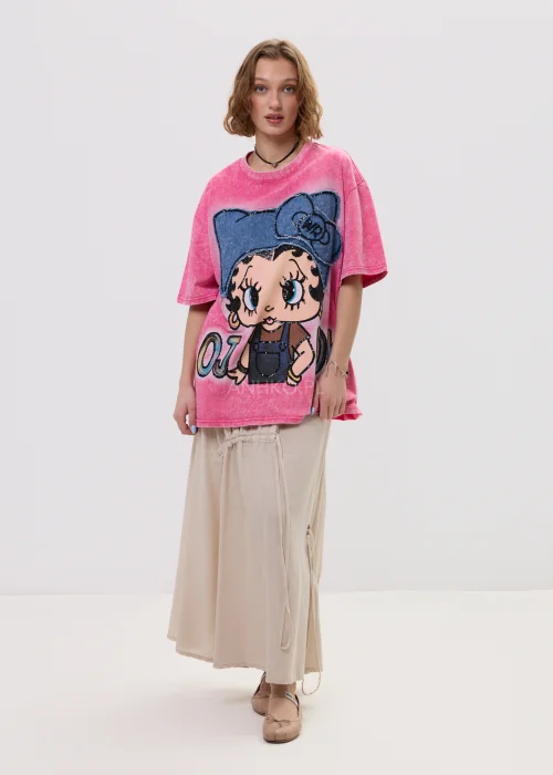 Różowy t-shirt damski oversize z nadrukiem postaci i cekinowymi detalami, luźny fason – stylizacja ze spódnicą.