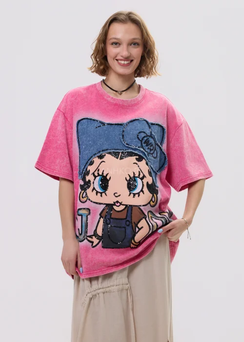 Różowy t-shirt damski oversize z nadrukiem postaci i cekinowymi detalami, luźny fason – stylizacja ze spódnicą.