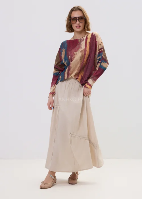 Sweter oversize w wielokolorowy, artystyczny print – odcienie bordo, beżu i niebieskiego, luźny fason, stylizacja z jasną spódnicą.