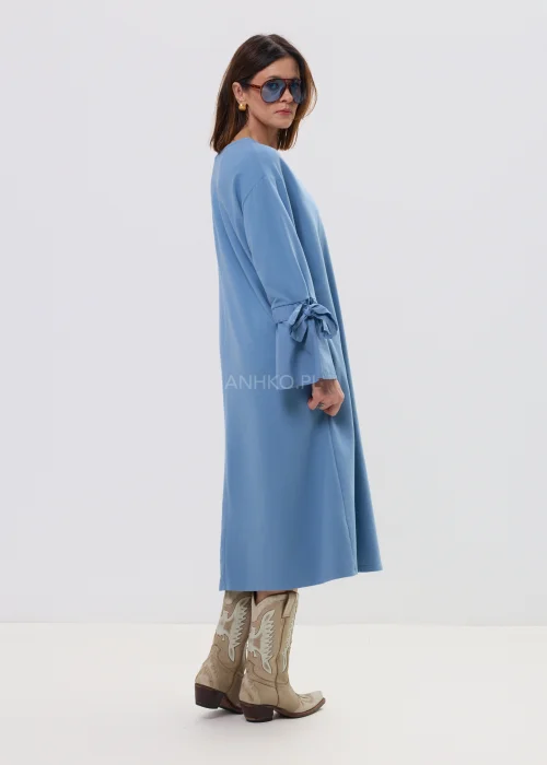 Sukienka damska midi w kolorze błękitnym, o luźnym, rozkloszowanym kroju z długim rękawem i wiązaniem przy mankietach, ozdobiona subtelną aplikacją – wygodna i stylowa propozycja na co dzień.