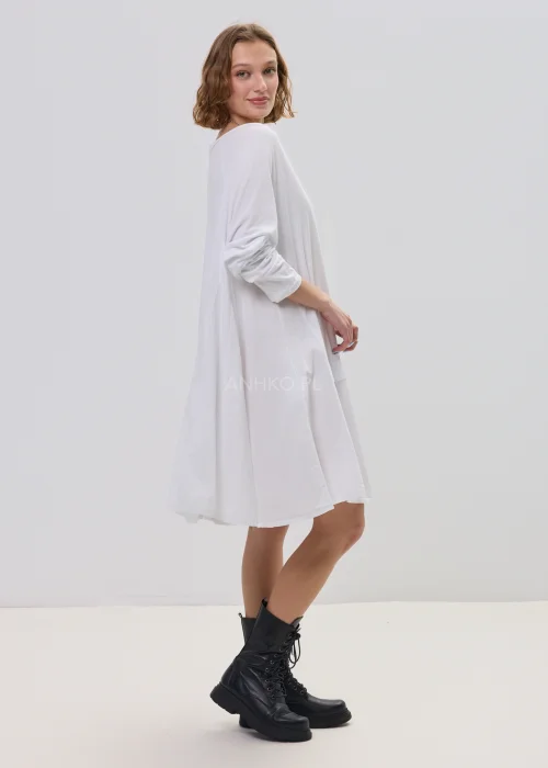 Biała sukienka oversize z falbaną u dołu, asymetryczny krój z dłuższym tyłem, stylizacja z botkami.