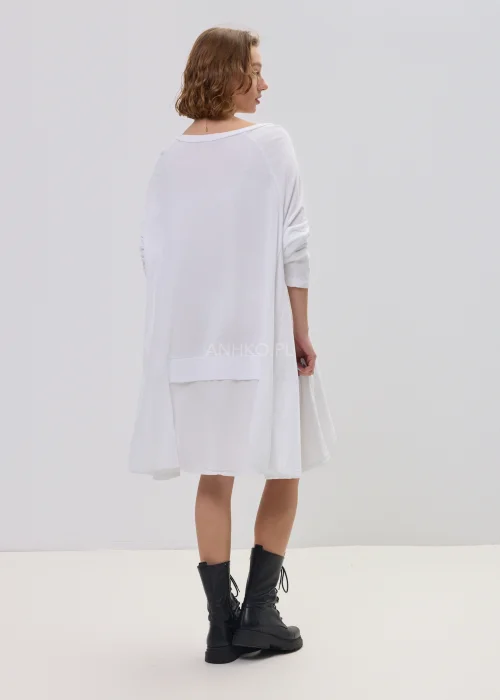 Biała sukienka oversize z falbaną u dołu, asymetryczny krój z dłuższym tyłem, stylizacja z botkami.