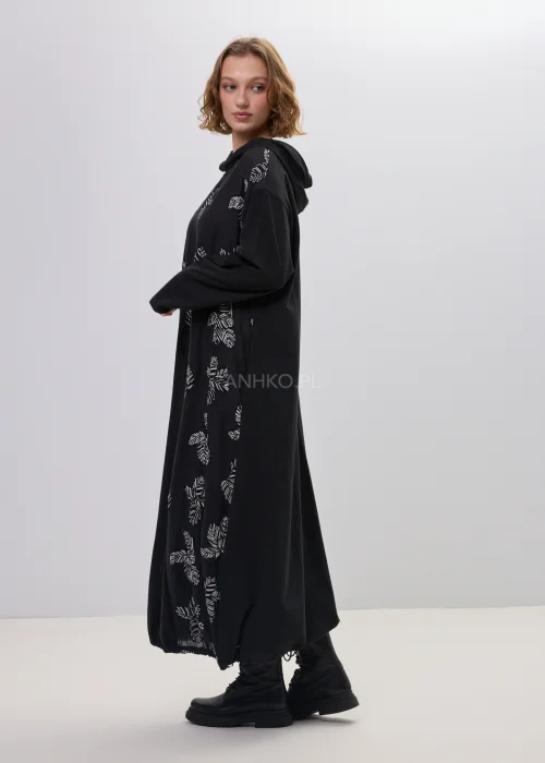 Sukienka maxi czarna z kapturem i subtelnym printem liści, o luźnym, wydłużonym kroju – minimalistyczna stylizacja z ciężkimi botkami.