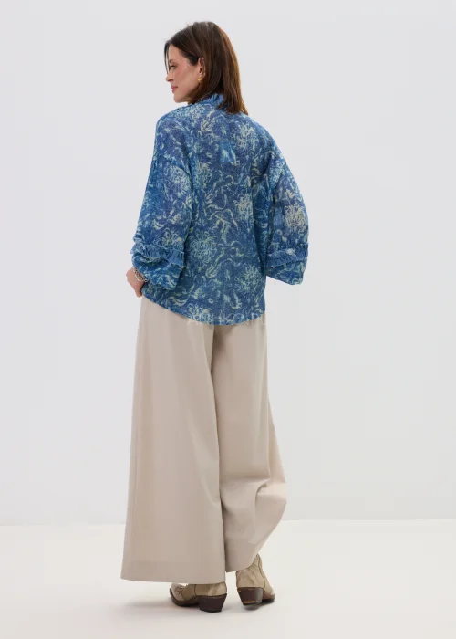 Beżowe spodnie damskie wide leg z wysokim stanem i szerokimi nogawkami, elegancki, lejący fason w nowoczesnej stylizacji.