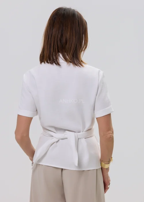 Biała bluzka damska koszulowa z krótkim rękawem i wiązaniem z ozdobną klamrą, elegancki fason – stylizacja ze spódnicą maxi.