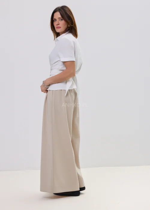 Biała bluzka damska koszulowa z krótkim rękawem i wiązaniem z ozdobną klamrą, elegancki fason – stylizacja ze spódnicą maxi.