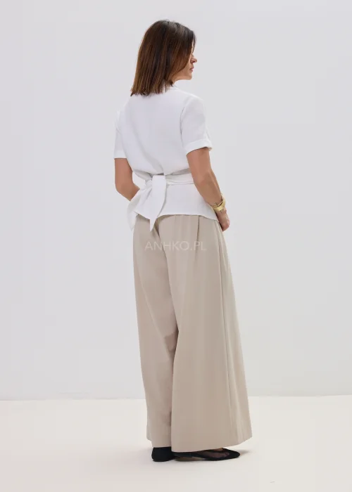 Biała bluzka damska koszulowa z krótkim rękawem i wiązaniem z ozdobną klamrą, elegancki fason – stylizacja ze spódnicą maxi.