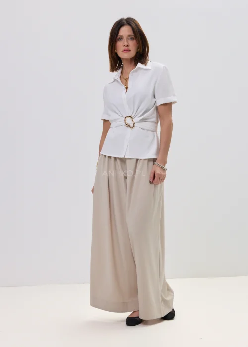 Biała bluzka damska koszulowa z krótkim rękawem i wiązaniem z ozdobną klamrą, elegancki fason – stylizacja ze spódnicą maxi.