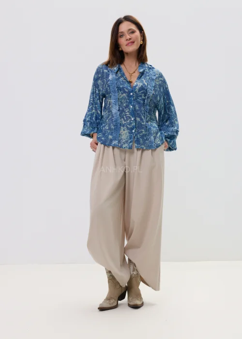 Niebieska koszula damska oversize z printem i falbankami, zapinana na guziki, lekki materiał w stylowej, casualowej stylizacji.