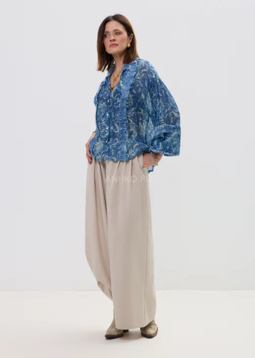 Niebieska koszula damska oversize z printem i falbankami, zapinana na guziki, lekki materiał w stylowej, casualowej stylizacji.