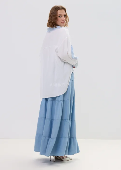 Niebieska spódnica maxi z elastyczną talią i falbanami, lekki, rozkloszowany fason w kobiecej stylizacji.