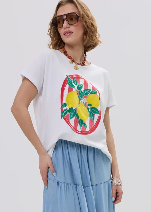Biały t-shirt damski z nadrukiem cytryn i liści w czerwonej ramie, luźny fason – stylizacja ze spódnicą maxi i biżuterią.