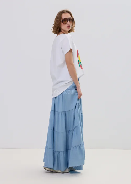 Biały t-shirt damski z nadrukiem cytryn i liści w czerwonej ramie, luźny fason – stylizacja ze spódnicą maxi i biżuterią.