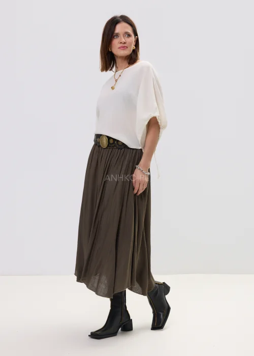 Spódnica midi brązowa o zwiewnym, asymetrycznym kroju z delikatnym połyskiem, stylizowana z szerokim paskiem z ozdobną klamrą i botkami na obcasie.