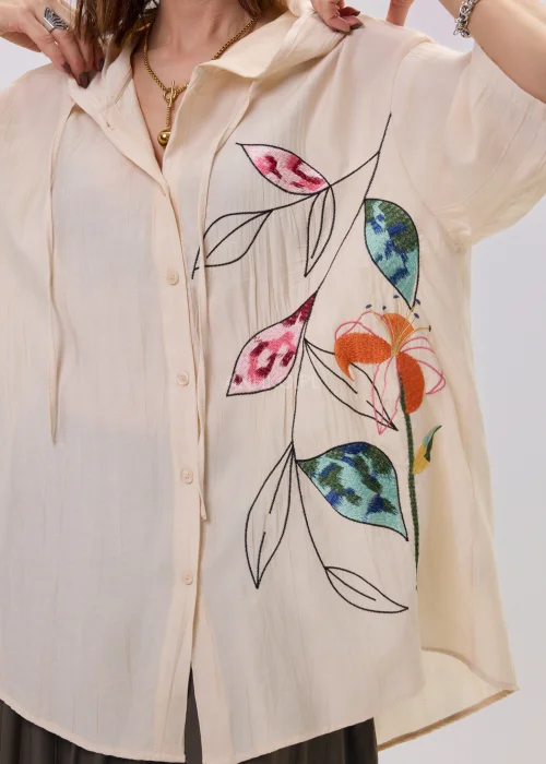 Koszula oversize beżowa z artystycznym haftem roślinnym, lekka i zwiewna, z guzikami i luźnym krojem – stylizacja casual z nutą boho.