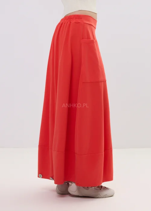 koralowa spódnica midi o luźnym kroju z wysokim stanem i naszywanymi kieszeniami, minimalistyczny fason w casualowej stylizacji.