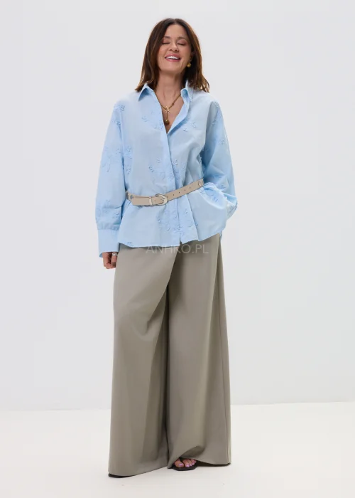 Beżowe spodnie damskie wide leg z wysokim stanem i kopertowym zapięciem, elegancki fason z szerokimi nogawkami w miejskiej stylizacji.