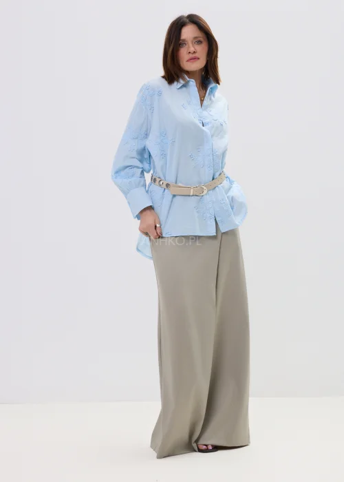 Koszula oversize błękitna z haftem kwiatowym, zapinana na guziki, z długim rękawem i klasycznym kołnierzem – elegancko-casualowa stylizacja z paskiem w talii.