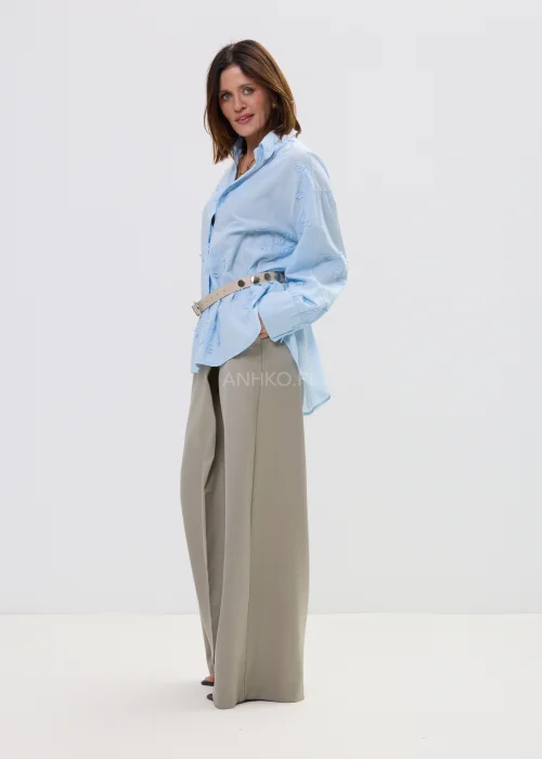 Koszula oversize błękitna z haftem kwiatowym, zapinana na guziki, z długim rękawem i klasycznym kołnierzem – elegancko-casualowa stylizacja z paskiem w talii.