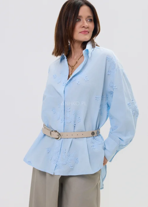 Koszula oversize błękitna z haftem kwiatowym, zapinana na guziki, z długim rękawem i klasycznym kołnierzem – elegancko-casualowa stylizacja z paskiem w talii.