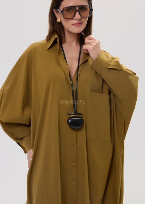 Oliwkowa koszula damska oversize o wydłużonym kroju z klasycznym kołnierzem i kieszenią, luźny fason w nowoczesnej stylizacji.