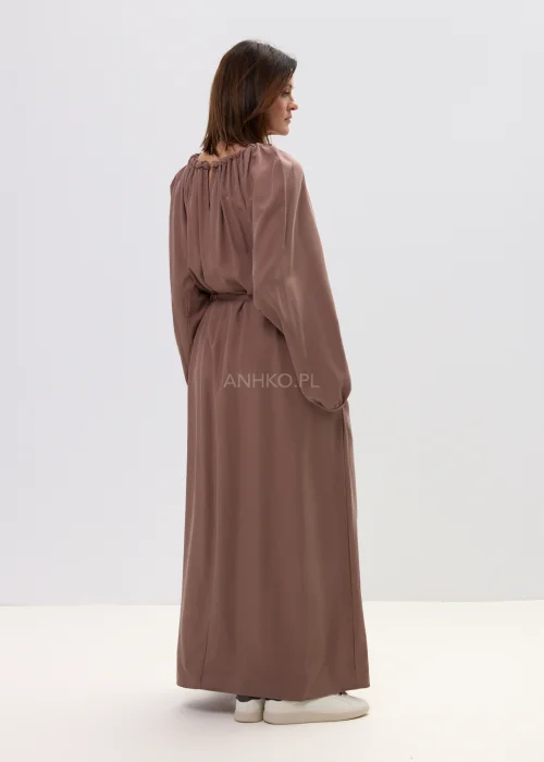 Sukienka maxi brązowa z marszczonym dekoltem i wiązaniem w talii, o płynnie opadającym fasonie – elegancka, minimalistyczna stylizacja z długim rękawem.