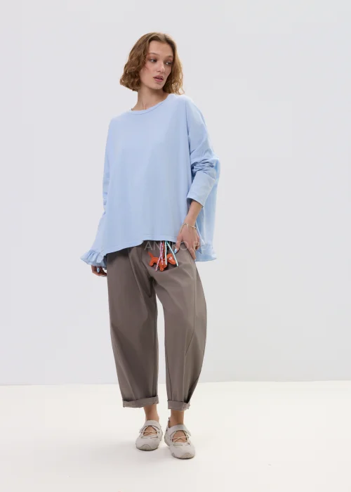 Spodnie damskie o luźnym kroju w kolorze taupe, z elastyczną talią i podwiniętymi nogawkami, ozdobione designerskim brelokiem – komfortowy model do codziennych stylizacji.