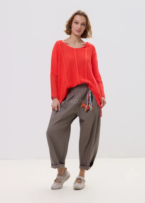Sweter damski o luźnym kroju w intensywnym koralowym kolorze, z ażurowymi rękawami i obniżoną linią ramion, lekki i stylowy element codziennych stylizacji.