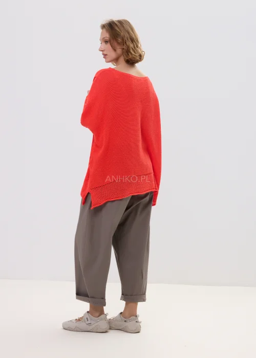 Sweter damski o luźnym kroju w intensywnym koralowym kolorze, z ażurowymi rękawami i obniżoną linią ramion, lekki i stylowy element codziennych stylizacji.