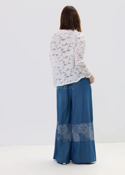 Niebieskie spodnie damskie wide leg z szerokimi nogawkami i ozdobnym panelem z wzorem, luźny fason w stylowej, casualowej stylizacji.