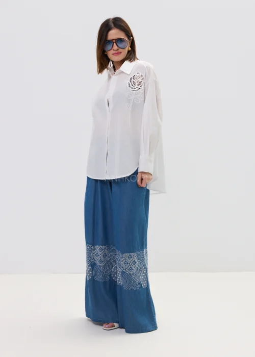 Biała koszula damska z haftowaną aplikacją róży, luźny fason, lekko transparentny materiał, elegancki styl.