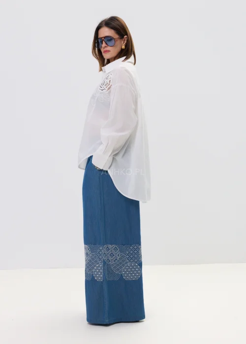 Biała koszula damska z haftowaną aplikacją róży, luźny fason, lekko transparentny materiał, elegancki styl.