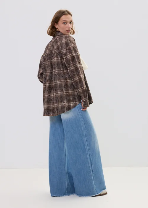 Brązowa koszula damska w kratę oversize z klasycznym kołnierzem i zapięciem na guziki, luźny fason w casualowej stylizacji.