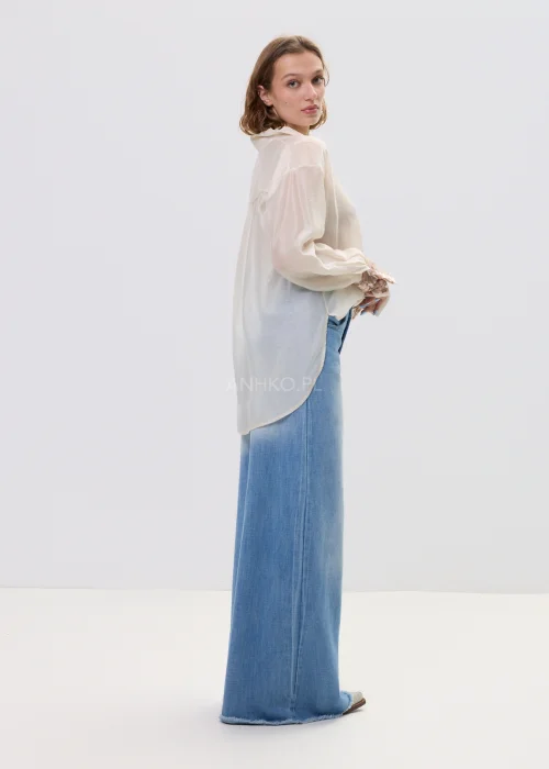 Beżowa koszula damska z cekinową kieszenią i mankietami, luźny fason, lekko transparentny materiał, styl casual-elegant.